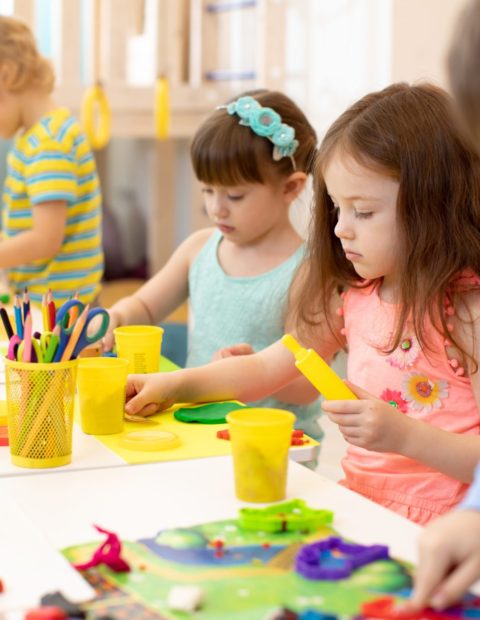 Art and craft activity in kindergarten. Preschool kids hands working in day care center. Group of children engaged in handcrafts